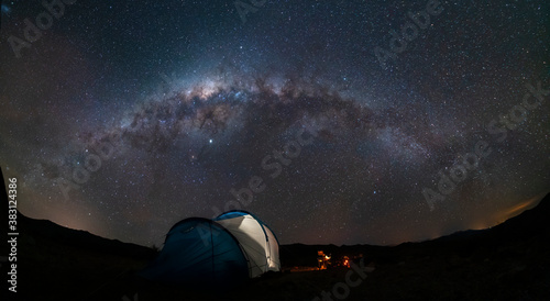 An amazing night sky at Atacama Desert. A tent, a campfire and the milky way over us, just an awe nightscape over our base camp inside Atacama arid desert. Amazing view over Sagittarius night stars