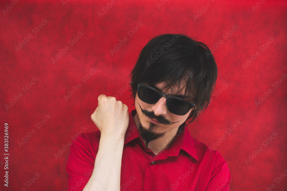 Male portrait. young man with sunglasses in red shirt on the red background Male portrait. young man with sunglasses in red shirt on the red background