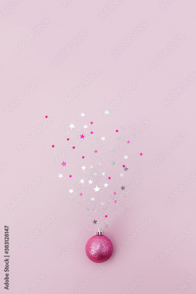 Christmas ball sparkles with star confetti on pink background. Minimal concept of the New Year. Vertical banner, place for text. Christmas ball sparkles with star confetti on pink background. Minimal concept of the New Year. Vertical banner, place for text.