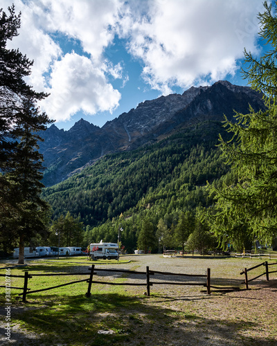 area for campers fenced with a wooden fence in the alps against the backdrop of mountains