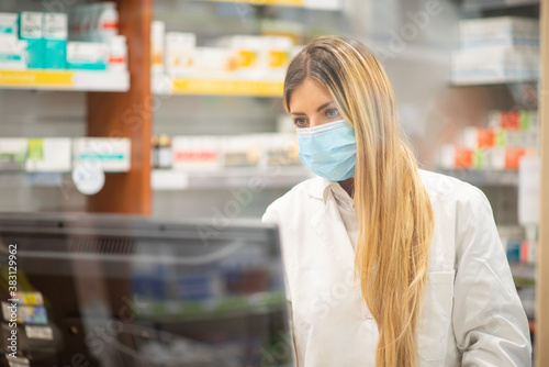 Masked cashier in a pharmacy, coronavirus concept