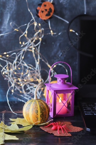 Halloween mystical decor, lantern with burning candle, autumn leaves on a black background, decorated home interior for the holiday, fabulous atmosphere