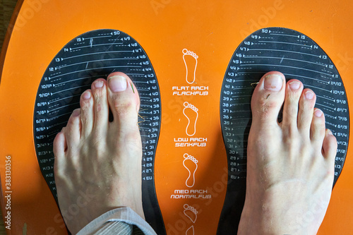 Man feet on the scales to measure their feet size. 