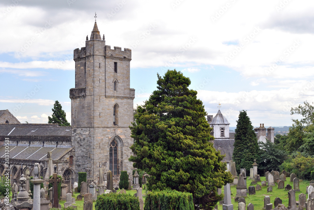 Ancient Stone Church & Tower in Cemetery with Trees & Old Headstones