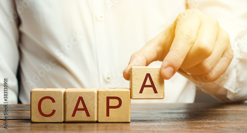 Photos Businessman puts wooden blocks with the word CAPA