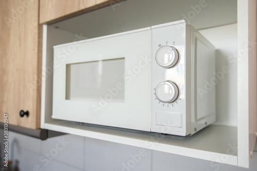 White microwave on the kitchen shelf