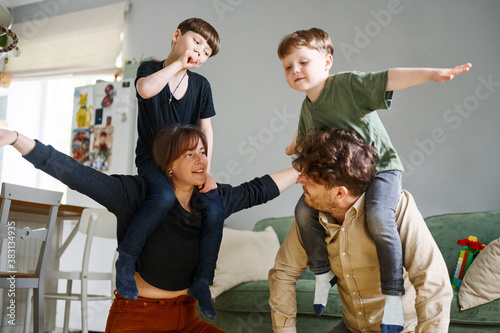 Happy family with little son's having fun at home. Smiling parents and preschool children having fun together, family enjoying free time