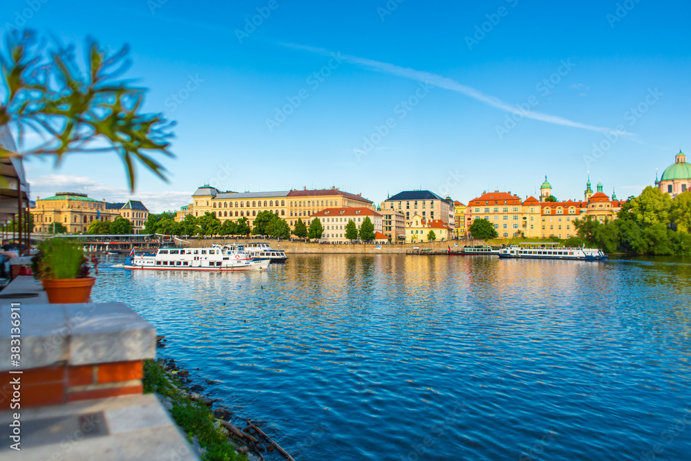 Prague city embankment Vltava river. City landscape, ferries with tourists float along the river