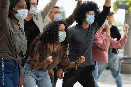 Young people in face masks attending demonstration on the street