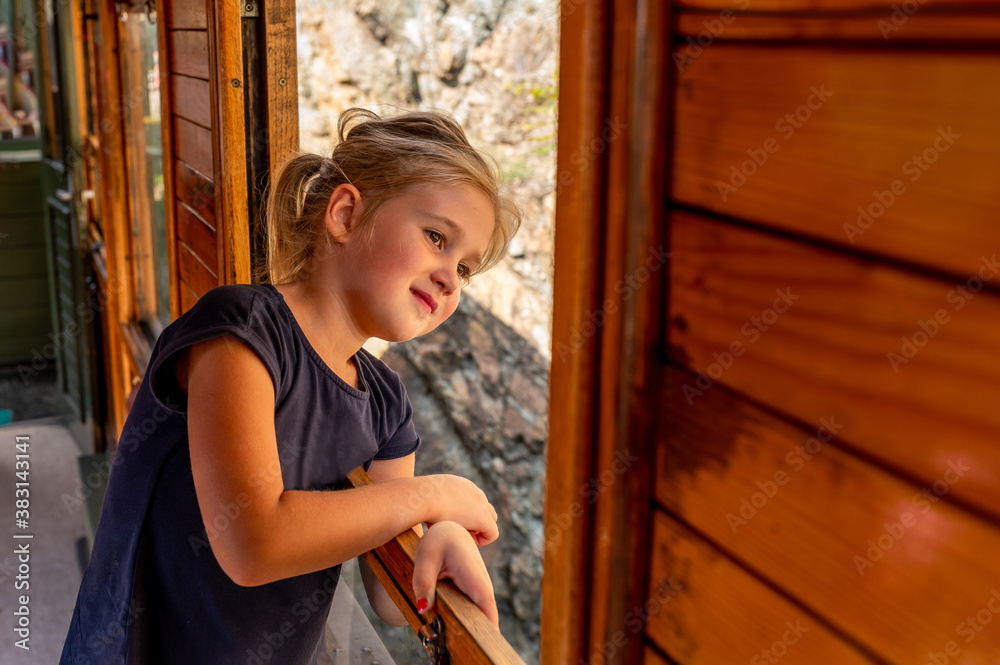Portrait of cute little girl looking out from window while traveling by train Portrait of cute little girl looking out from window while traveling by train