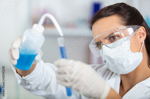 young woman working with liquids in glassware