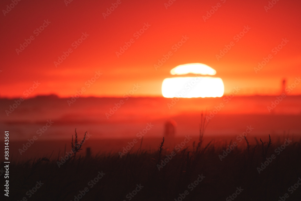 Background blur of the sun just dipping below the horizon over the ocean at sunset. Selective focus with Copy space