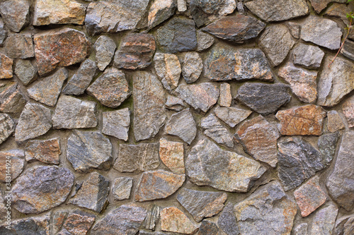 Texture wall made of stones. The wall is made of stones fortified with concrete