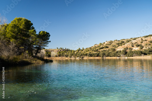 Beautiful lagoon with trees and mountains in the background in the natural park of 'Lagunas de Ruidera' in Ossa de Montiel, Albacete, Spain photo