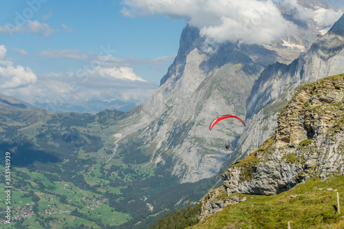 Closeup of a red para glider flying in Swiss Alps. 