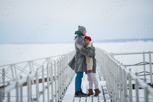 Konstfotografi Lovers warm each other with love and hugs on a winter walk along the pier on the lake