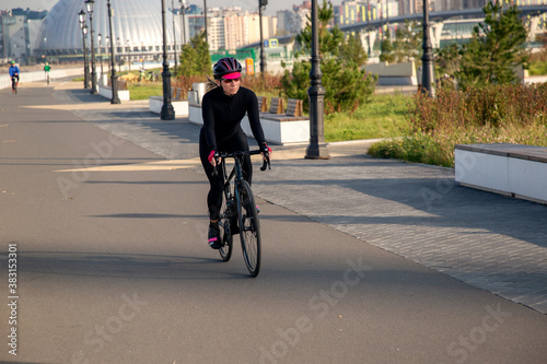Woman rides a bike in the park. Cycling. Outdoor sports. Russia St. Petersburg.Cycling workout © Алексей Васильев