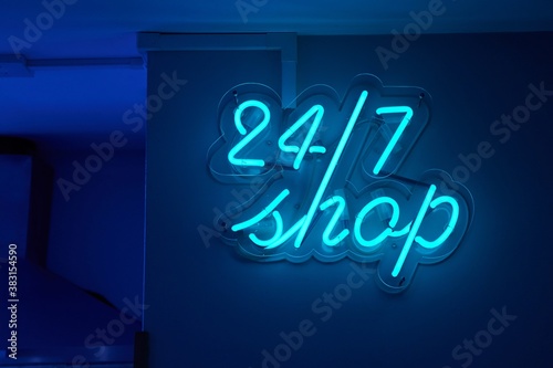 Twenty-four hours shop neon sign glowing on a wall photo