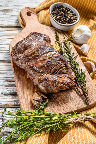 Grilled flank steak on a chopping Board with seasonings and spices. White background. Top view