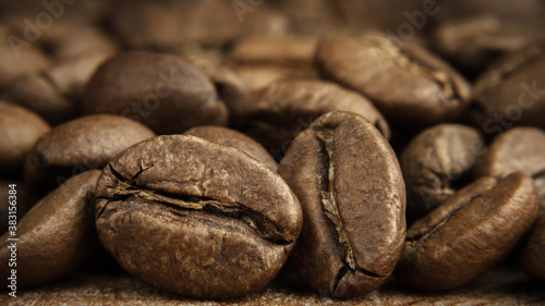 medium roasted coffee beans scattering close-up with soft background and selective focus in foreground. artistic macro photography. front side view