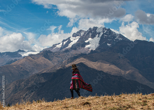 A Quechua Woman walks across an Andean ridge near Cusco, Peru photo