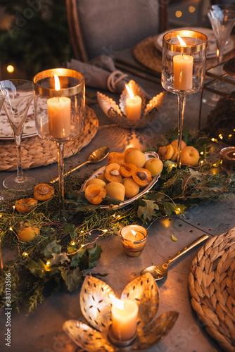 Christmas table with candles  flowers and fruits