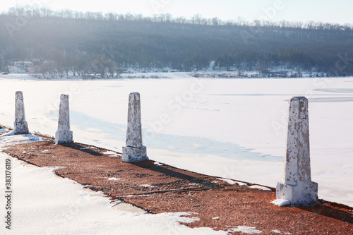Pillars at the frozen lake shore 