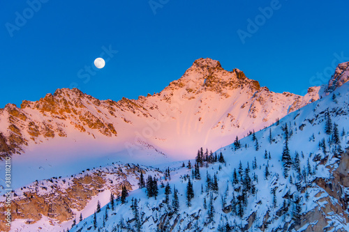 full moon rising over mountain peak