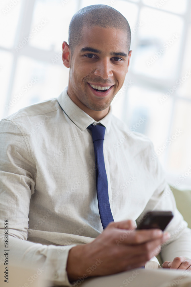 Fototapeta premium Portrait smiling young businessman using smart phone