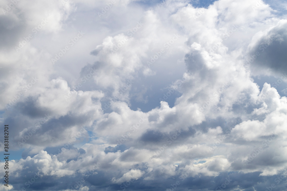 The blue sky shines through the clouds. Beautiful white cumulus clouds in the blue sky The blue sky shines through the clouds. Beautiful white cumulus clouds in the blue sky