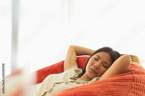 Serene young woman napping in beanbag chair