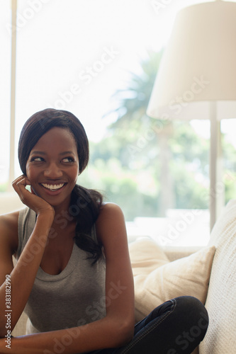 Obraz na plátne Portrait happy mischievous young woman on sofa