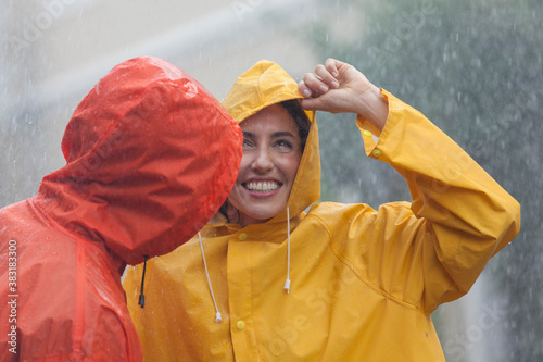 Εκτύπωση καμβά Happy young couple in raincoats standing in rain