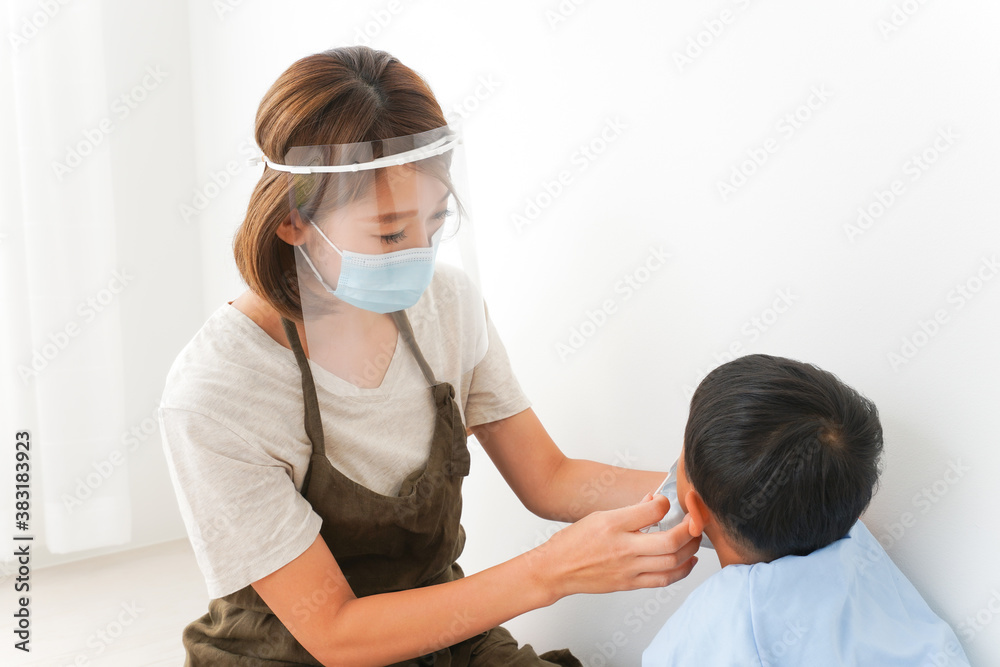 Obraz premium 園児にマスクをつける保育士