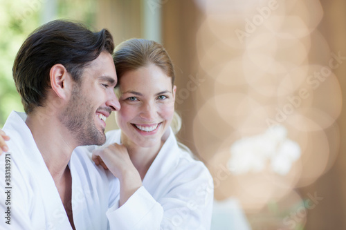 Bild auf Leinwand Portrait happy young couple in bathrobes hugging in spa