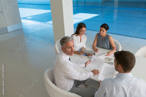 Corporate business people discussing paperwork in modern office