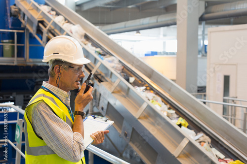 Φωτογραφία Male supervisor with walkie talkie in recycling plant