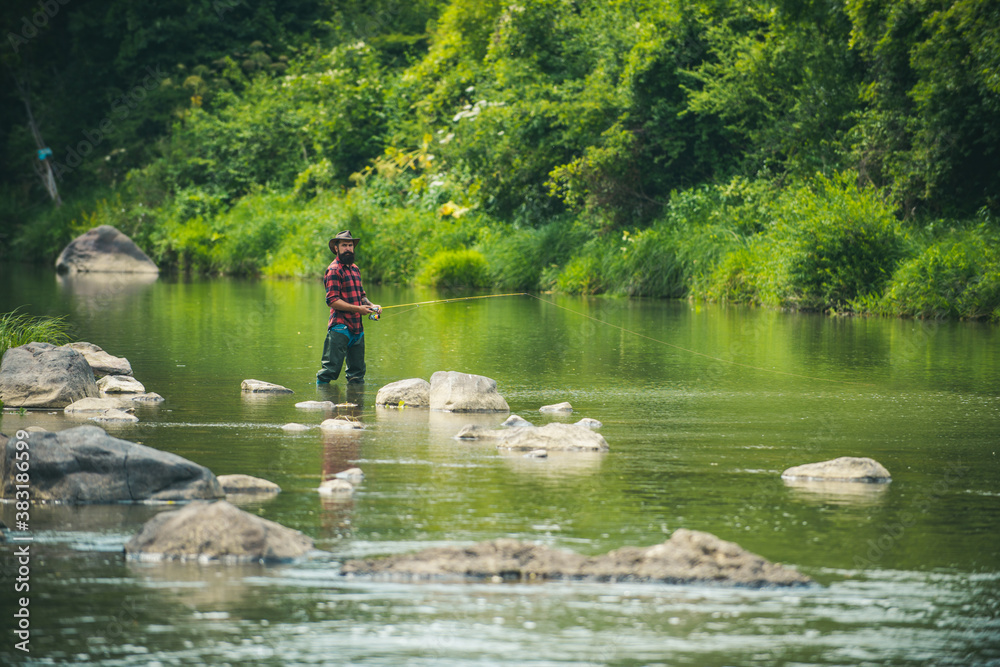 Man fisherman catches a fish. Fishing skills. Fly fish hobby of man. Cheerful fisherman fishing in a river outdoors. Summer vacation. Fishing requires to be mindful and fully present in moment. Man fisherman catches a fish. Fishing skills. Fly fish hobby of man. Cheerful fisherman fishing in a river outdoors. Summer vacation. Fishing requires to be mindful and fully present in moment.