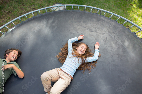 Carefree kids laying on trampoline