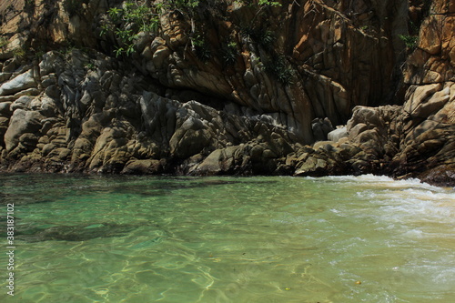 the beach near mountain with rocks and water
