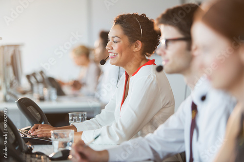 Tableau sur toile Happy young businesswoman with headset working in call center