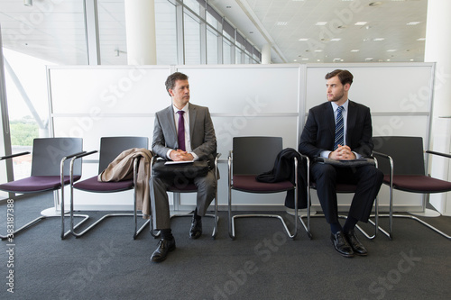 Slika na platnu Competing businessmen waiting for job interview in office lobby