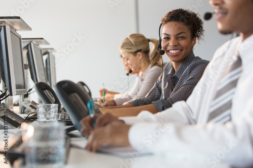 Portrait confident businesswoman with headset working in call center