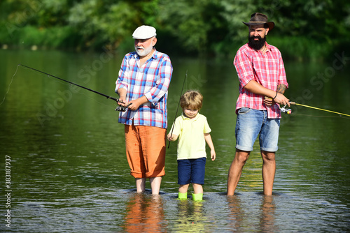 Father, son and grandfather relaxing together. Coming together. I love fishing. Senior man fishing with son and grandson. Happy weekend concept.