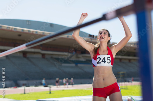 Photos Happy female track and field athlete cheering at high jump