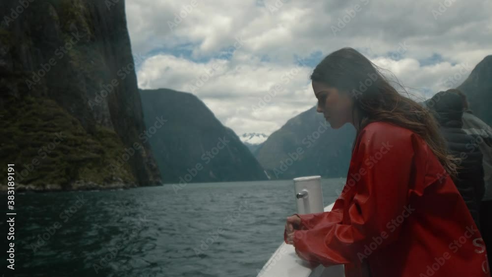 Woman looking out over edge of a boat in exotic ocean bay Woman looking out over edge of a boat in exotic ocean bay