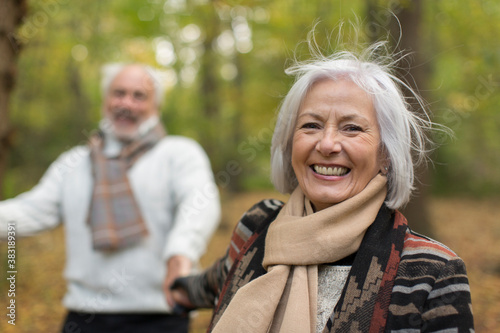 Portrait happy senior woman in autumn park