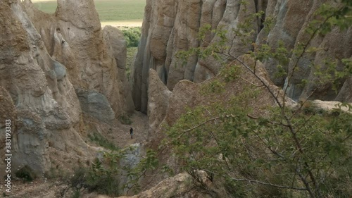 Woman hiking up toward giant clay cliffs