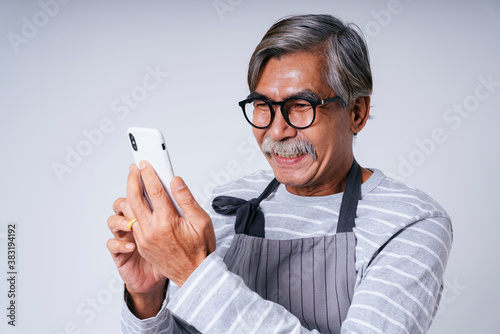 Old elderly senior waiter using smartphone isolate on white background.
