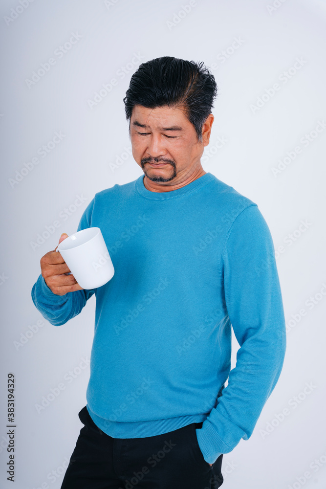 Senior man in blue long sleeve shirt with white coffee cup. Senior man in blue long sleeve shirt with white coffee cup.